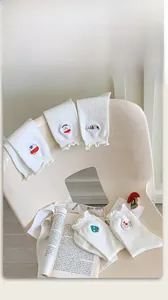 Detail of white cotton socks with lettuce trim edges and cute cartoon embroidery