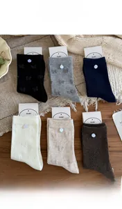 Flat lay of colorful cotton mid-tube socks with bow texture and decorative buttons