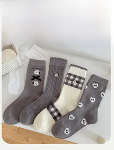 Close-up of four pairs of grey cartoon dog and bow embroidery cotton crew socks