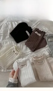 Détail de chaussettes en coton côtelé avec bords festonnés et étiquette tissée texte