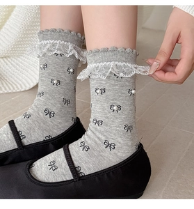 Detail of grey socks with black bows, pearls and lace trim styled with Mary Janes