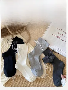 Détail de la texture tricotée de chaussettes mi-mollet avec nœuds en strass chic