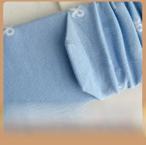 Détail macro de chaussettes tricotées bleu clair avec nœuds blancs et talon renforcé