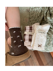Detail of vintage brown plaid and floral cotton socks with delicate bow accents