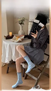 Détail de chaussettes en coton avec nœuds blancs et bords à volants gris en trois couleurs