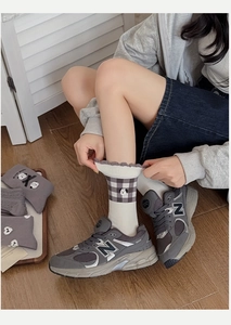 Detail of grey plaid cotton socks with ruffled edges and small dog embroidery