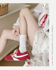 Gros plan de chaussettes en coton peigné blanc avec nœud papillon et texture côtelée