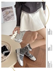 Detail of sweet lace trim socks with pearl accents and bow patterns in soft gray