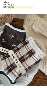 Detail of vintage brown floral and plaid cotton socks with delicate ruffle cuffs