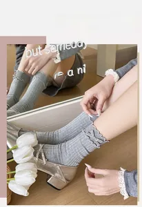 Detail of grey ruffled knit socks with velvet bow and delicate ribbed texture
