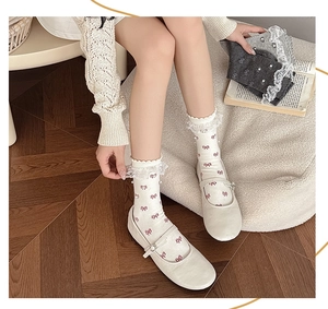 Detail of sweet lace trim socks with bow patterns and elegant ruffled edges in grey
