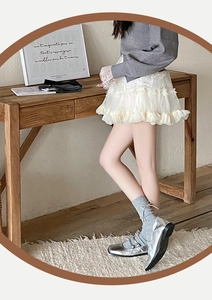 Détail de chaussettes grises avec nœud en strass et chaussures Mary Jane argentées