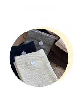 Detail of ribbed cotton socks with decorative bow buttons and butterfly jacquard pattern