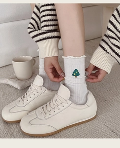 Detail of white cotton socks with green Christmas tree embroidery and retro gum sole shoes