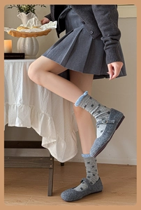 Détail de chaussettes grises à nœuds avec volants bleu clair et chaussures assorties