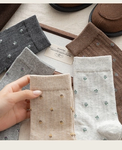 Détail de chaussettes en coton à motif floral en gris, beige et marron au style vintage