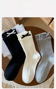 Close-up of cotton crew socks with double ruffle trim and velvet bow details