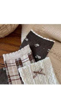 Detail of autumn vintage floral plaid socks with cute bows and ruffled edges in brown tones