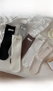 Détail de chaussettes en maille côtelée avec bords à volants et étiquettes en tissu