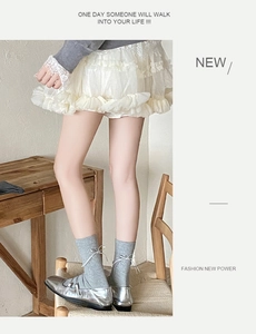 Détail de chaussettes grises avec nœuds blancs et chaussures Mary Jane argentées
