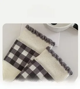 Detail of high-elasticity ruffled cuff on grey knitted socks with checkered patterns
