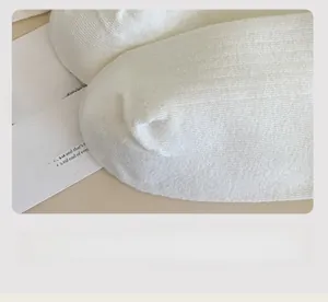 Detail of white cotton knitted socks showing seamless toe finish and soft texture
