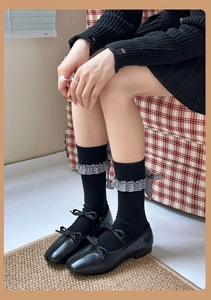 Détail de chaussettes Lolita grises avec nœuds et dentelle à carreaux et Mary Janes