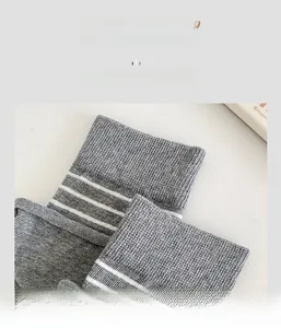 Detail of high-elastic ribbed cuffs with triple stripes on grey knit crew socks
