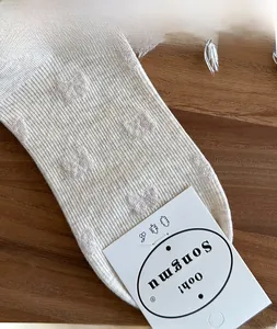 Close-up of high elasticity ribbed cuff on beige cotton socks with textured patterns