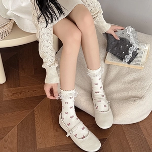 Lace trim crew socks with pearl accents and red bow prints worn with Mary Janes