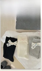 Dettaglio della maglia delle calze Lolita con fiocchi in pizzo in nero e bianco
