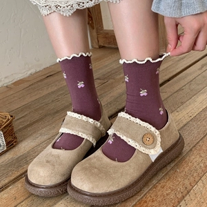 Retro khaki Mary Jane shoes with lace trim and purple floral socks on wooden floor