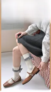 Détail de chaussettes en tricot crème avec nœud à carreaux et bordure à volants doux