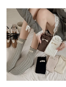 Gros plan de chaussettes en coton tricoté avec bords à volants et étiquette en tissu