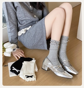 Detail of ballet style socks featuring delicate ruffle edges and elegant velvet bows