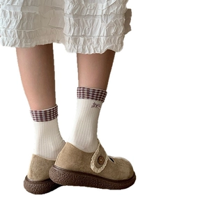 Retro white cotton crew socks with plaid bow cuffs paired with brown Mary Jane shoes
