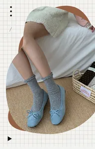 Detail of grey slouch socks with white polka dots and delicate ruffle trim design