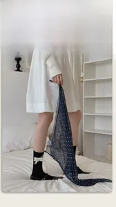 Dettaglio della pregiata fattura di una sciarpa in chiffon blu navy a pois bianchi