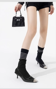 Detail of grey striped crew socks paired with black pointed heels and denim shorts