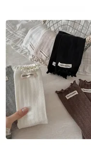 Détails de chaussettes en maille côtelée avec bords ondulés et étiquettes tissées