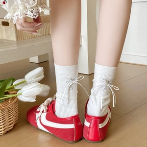 Chaussettes blanches avec nœud en ruban et papillon en strass sur tissu côtelé