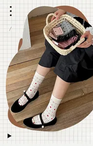 Baroque style knit crew socks with red heart patterns worn with black Mary Jane shoes