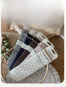 Five pairs of polka dot socks in various colors displayed in a vintage metal basket