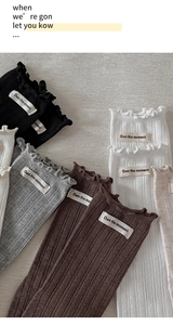 Gros plan de chaussettes en coton côtelé avec bords festonnés et étiquettes tissées
