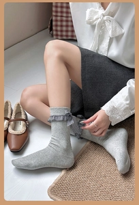 Détail de chaussettes grises côtelées avec nœud à carreaux et chaussures Mary Jane
