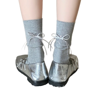 Chaussettes grises côtelées avec nœud en strass à l'arrière et chaussures argentées