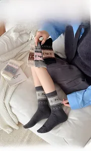 Close-up of Fair Isle crew socks featuring gray Nordic jacquard patterns and dog motifs
