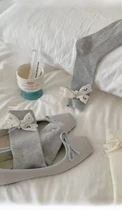 Dettaglio di calze Lolita in cotone con delicato fiocco in pizzo e nastri stile giapponese