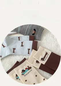 Detail süßer Dackel-Stricksocken in Blau, Beige und Grau mit weicher Baumwollstruktur