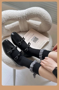 Détail de chaussettes grises style Lolita avec bordure en dentelle à carreaux et ruban nœud